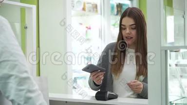 年轻可爱的白种人女孩通过支付通行证或支付波支付购买药品在药房。 非接触式卡